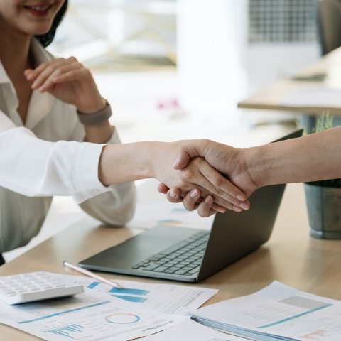 Financial accountants and marketers shaking hand to congratulate the real estate performance